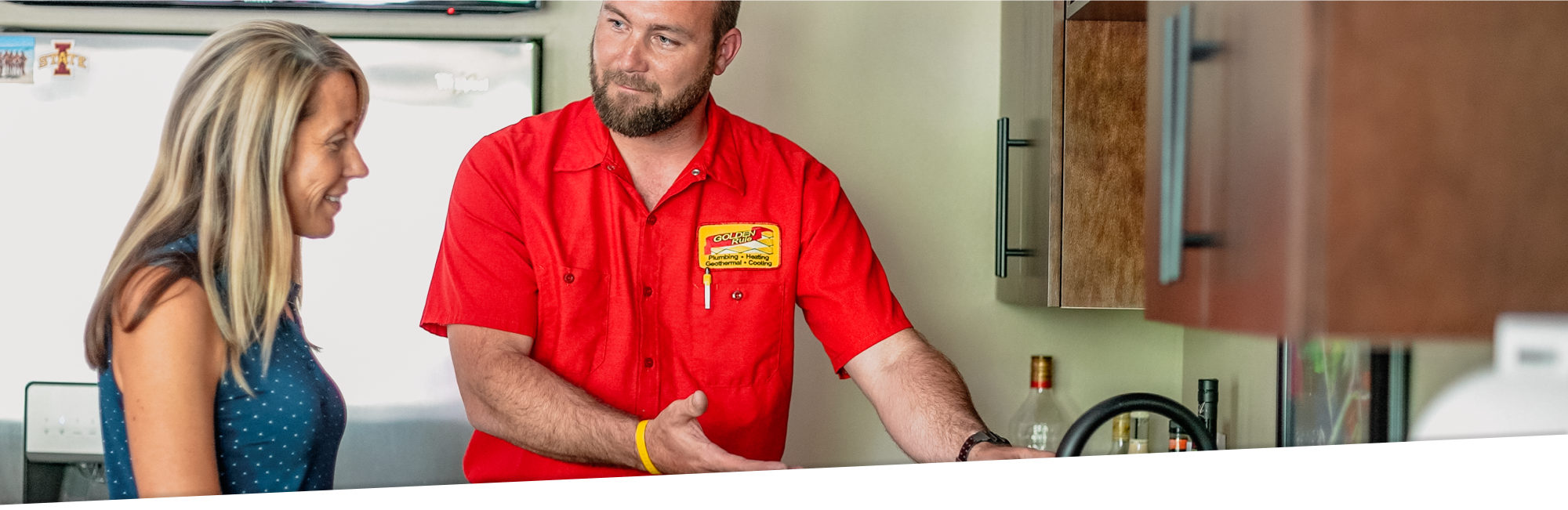 Golden Rule technician in red uniform helping homeowner