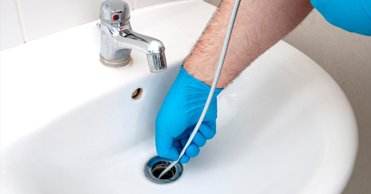 image of someone snaking a drain