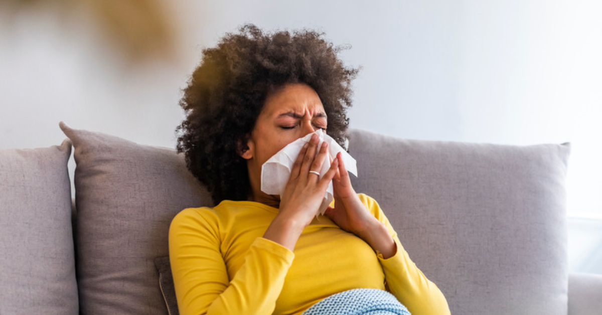 lady sneezing at home