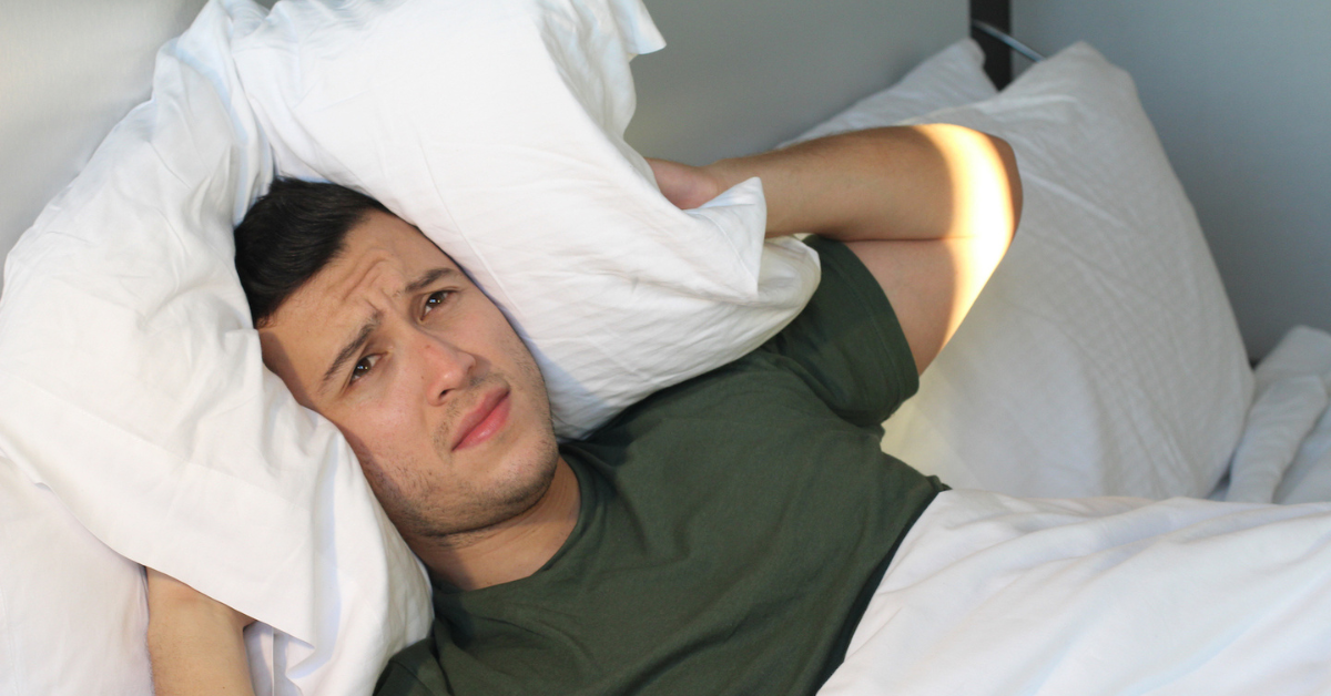 image of some using a pillow to block unwonted sounds