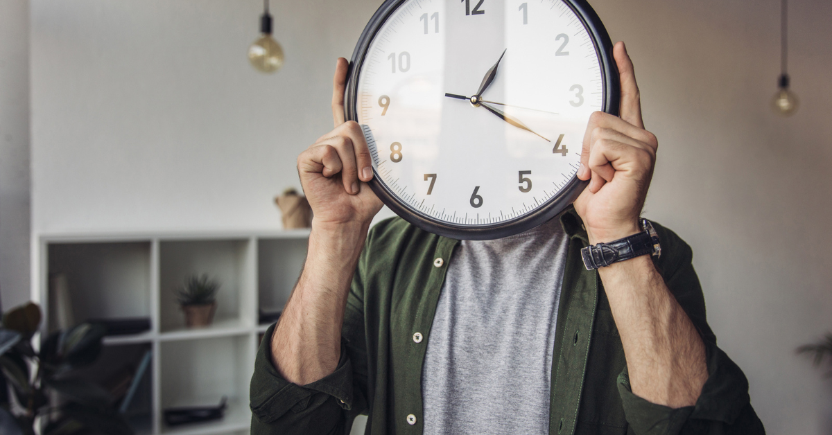 image of man hold clock in front of his face