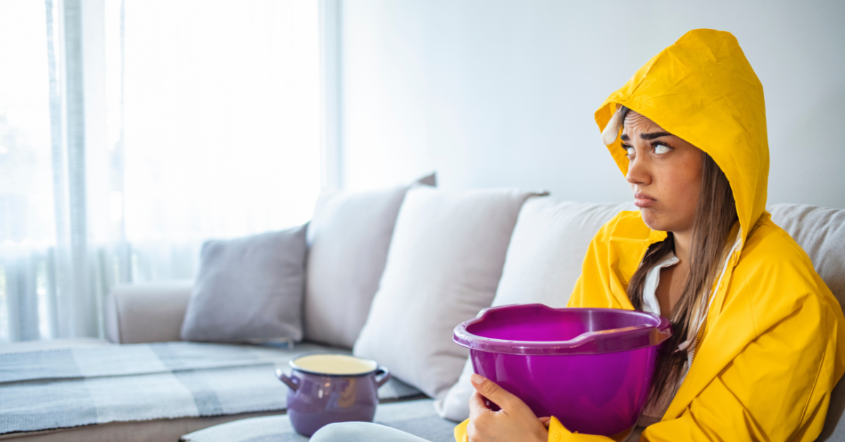 image of a female holding a bucket on a couch catching leaking water